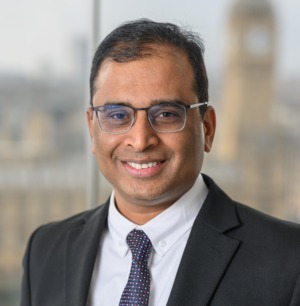 Smiling man wearing glasses and suit for professional head shot